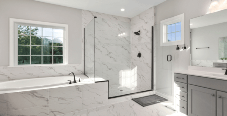 A luxury white marble bathroom filled with natural light.