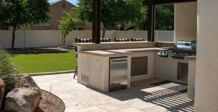 a large, sunny, outdoor kitchen with quartz, granite, or marble worktops